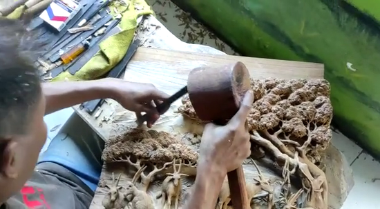 Artisan meticulously hand-carving a wooden sculpture, showcasing the skilled craftsmanship involved in creating personalized wooden wall art.