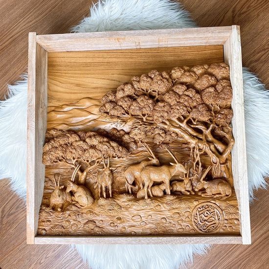 Completed relief carving of Qatar wildlife in the desert, featuring detailed representations of wild oxen and trees, exemplifying the final delivery of a custom wooden wall sculpture.